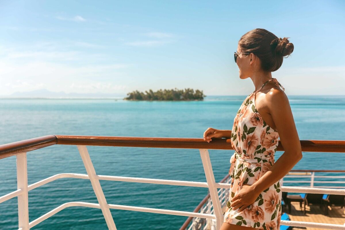 private jet summer destinations: woman on a yacht looking out onto the ocean